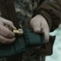 Hunter loading shotgun shells into a pouch