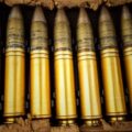 Large-caliber surplus cartridges in a wooden crate